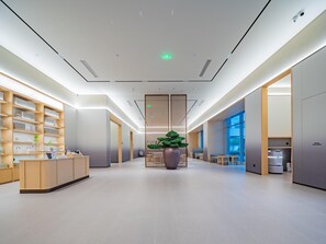 Un interior moderno con mostrador de recepción, estanterías y zona de estar.
