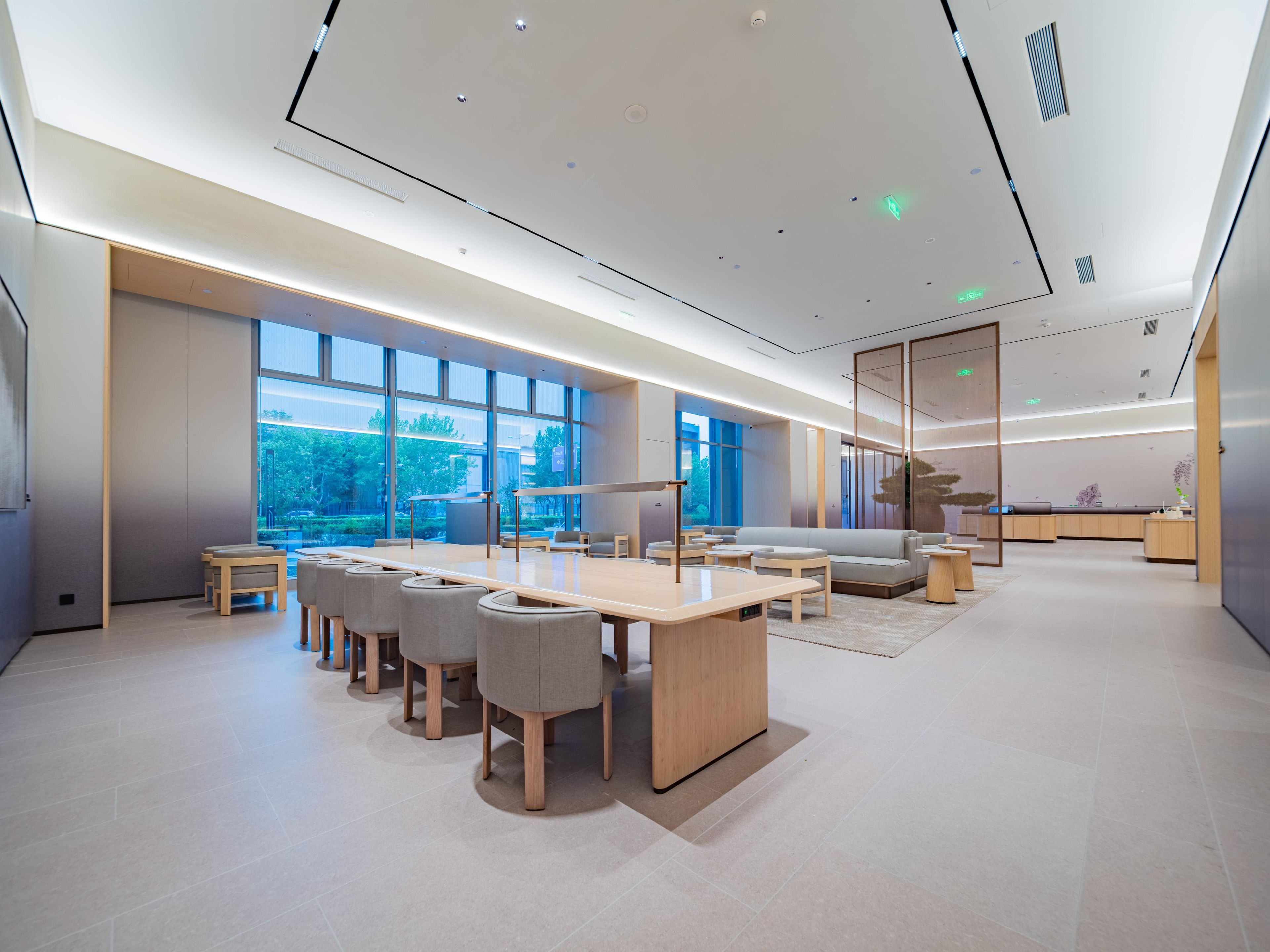 A modern conference room with a long table, chairs, and a sofa.