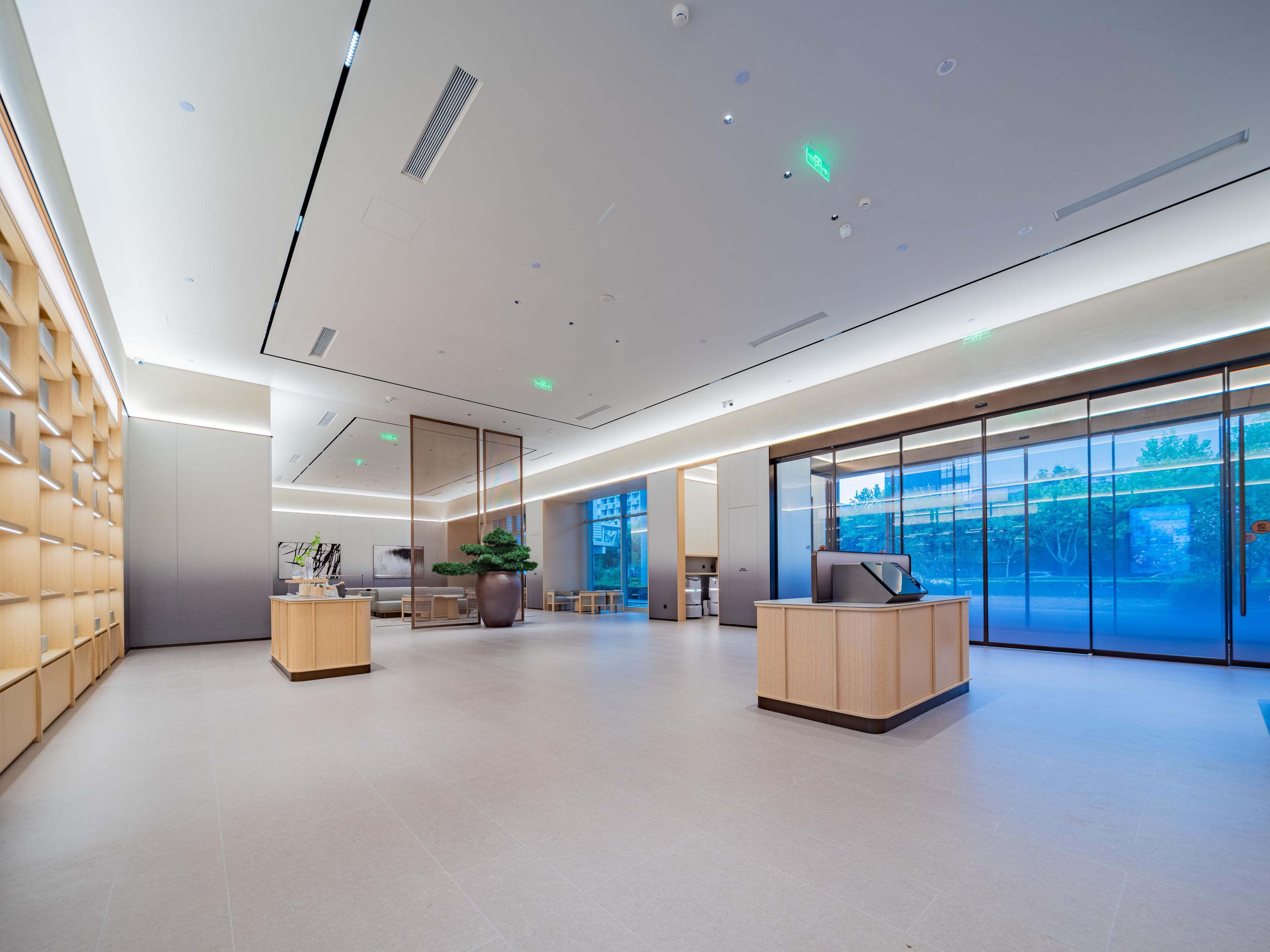 A modern interior with a reception desk, seating area, and large windows.