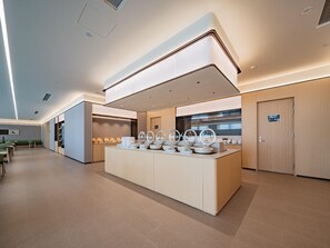 Eine moderne Hotelhalle mit einer zentralen Rezeption, einer Lounge und einer großen Spiegelwand.