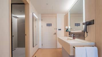 A modern bathroom with a shower, a sink with a mirror, and a towel rack.