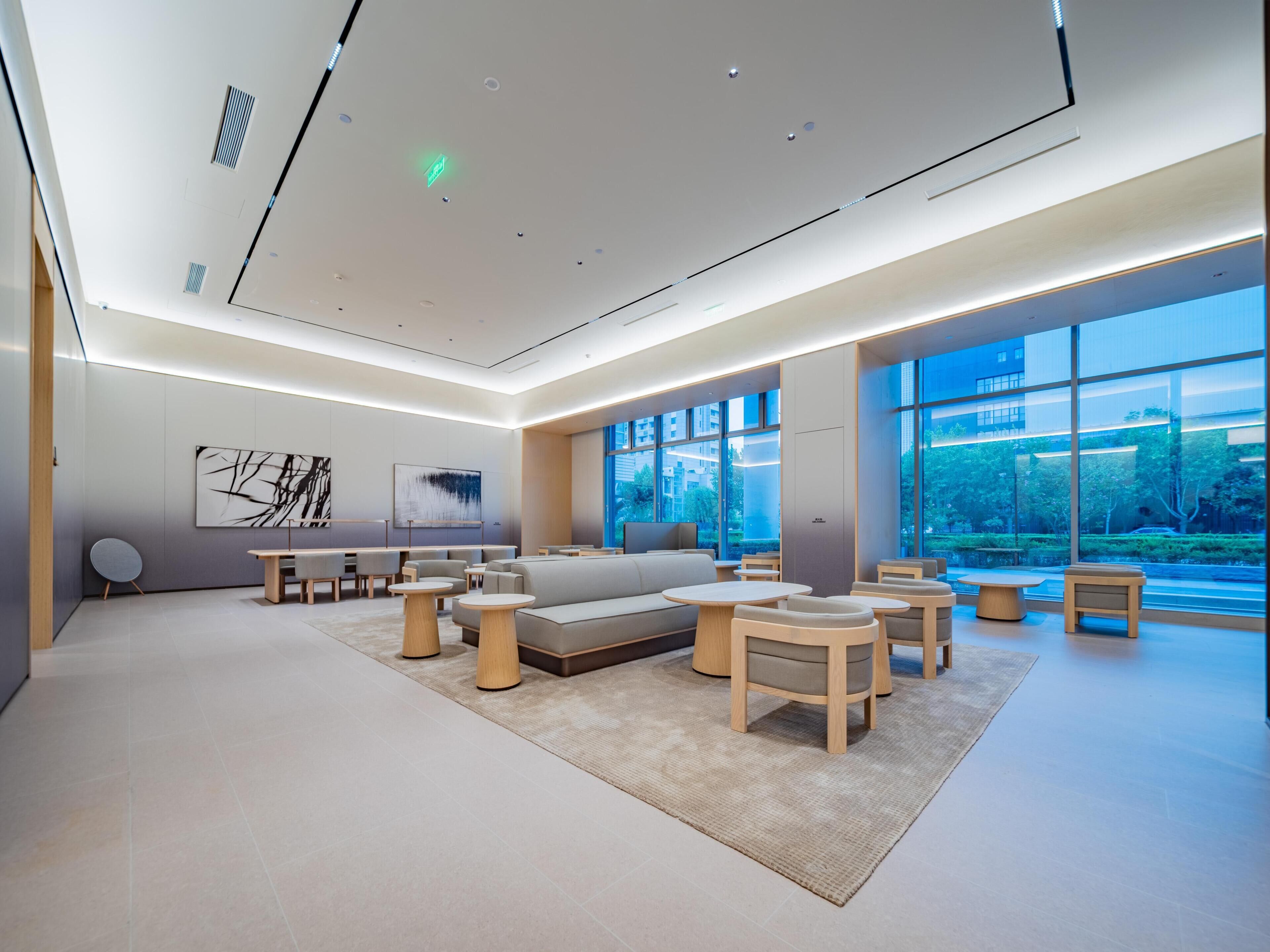 A modern interior with a seating area, large windows, and artwork on the walls.
