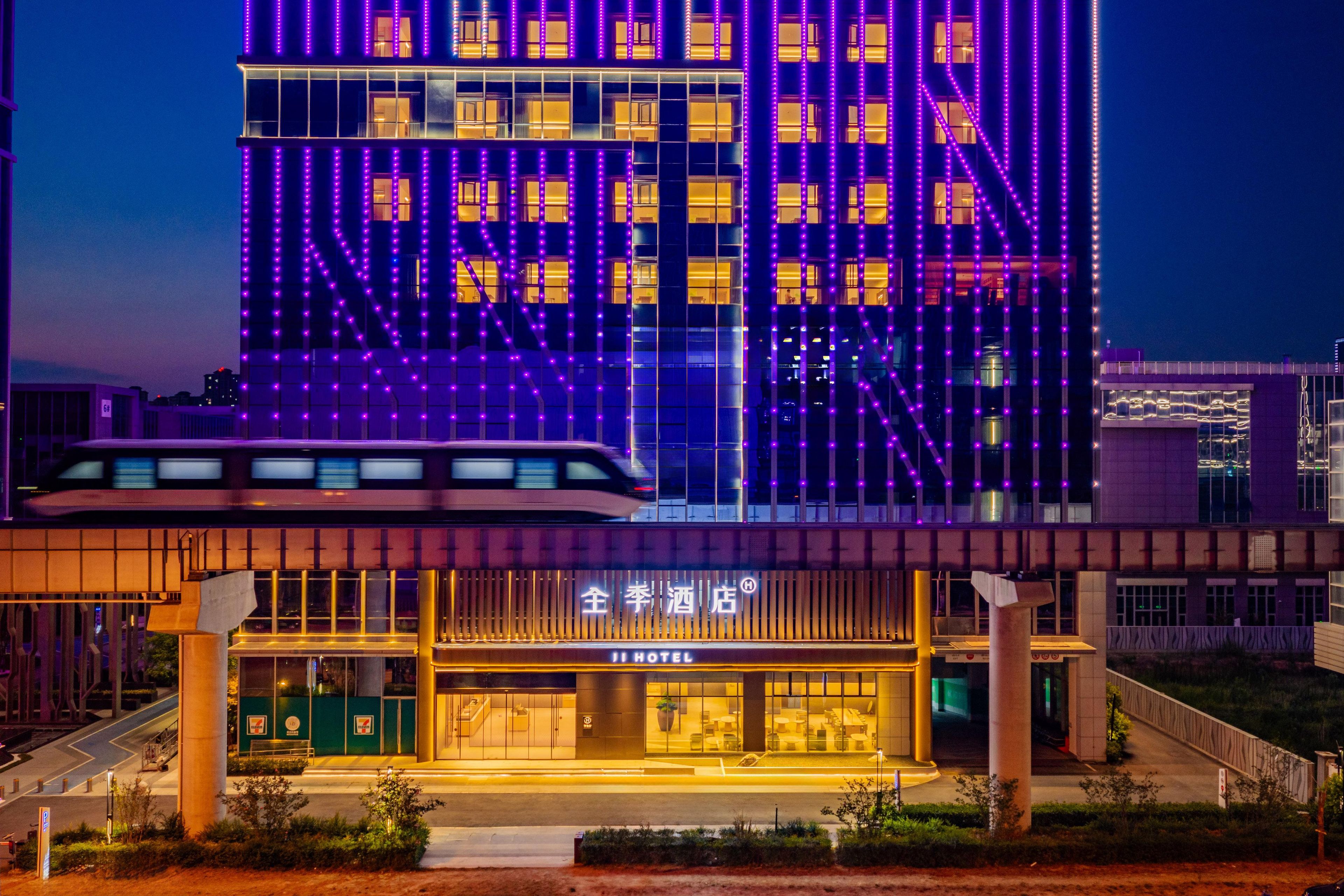 A hotel with a modern facade, illuminated windows, and a visible entrance with a sign.