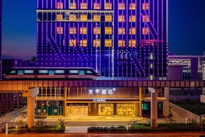A hotel with a modern facade, illuminated windows, and a visible entrance with a sign. - JI Hotel (Xi'an)