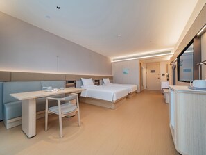 Een hotelkamer met een bed, een bureau, een stoel, een nachtkastje en een spiegel.