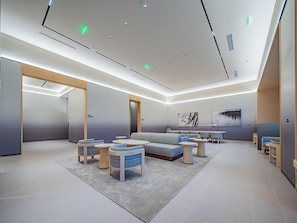 Una habitación de hotel moderna con una cama grande, zona de estar y obras de arte en las paredes.