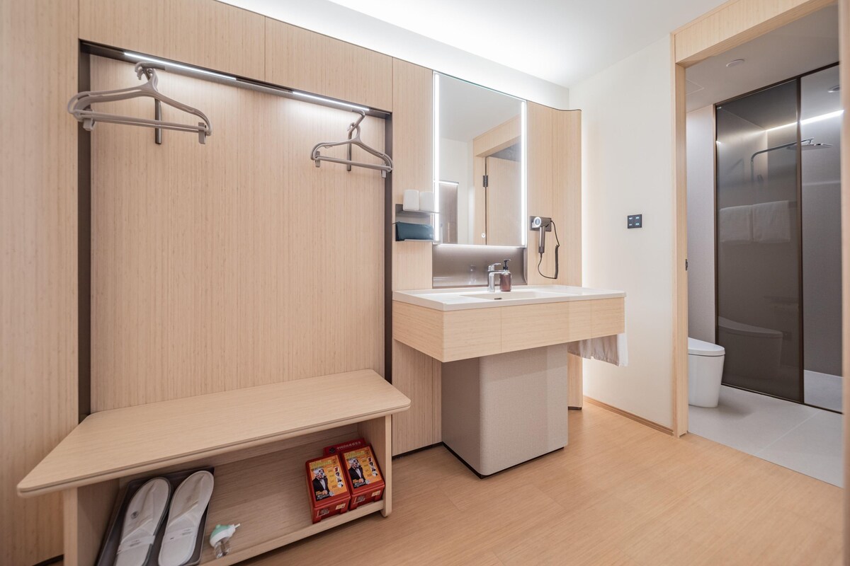 A modern bathroom with a vanity, mirror, towel rack, and shower enclosure.