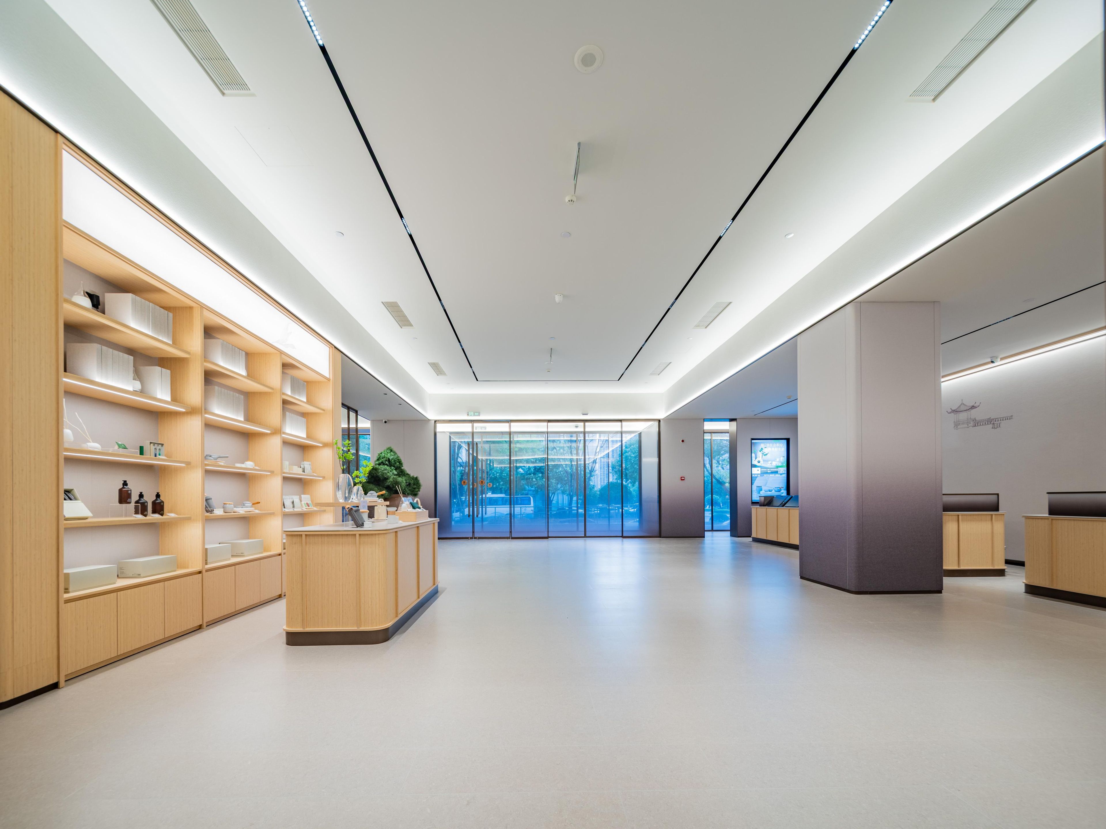 A modern interior with wooden shelving, a reception desk, and a glass door leading outside.