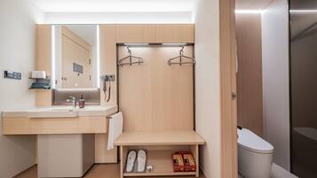 Un baño moderno con lavamanos, espejo, toallero y retrete.
