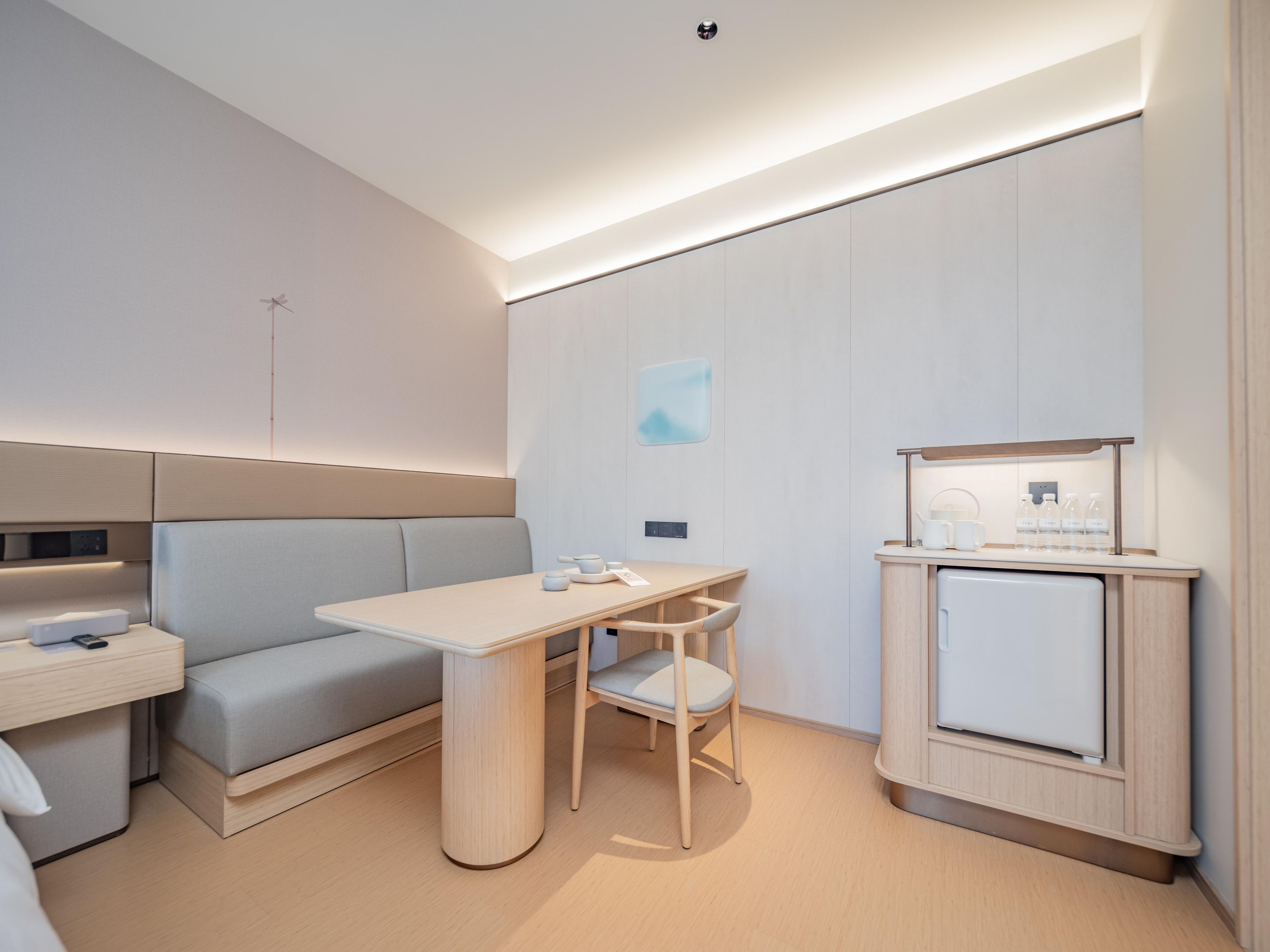 A modern, minimalist room with a sofa, a table, and a cabinet.