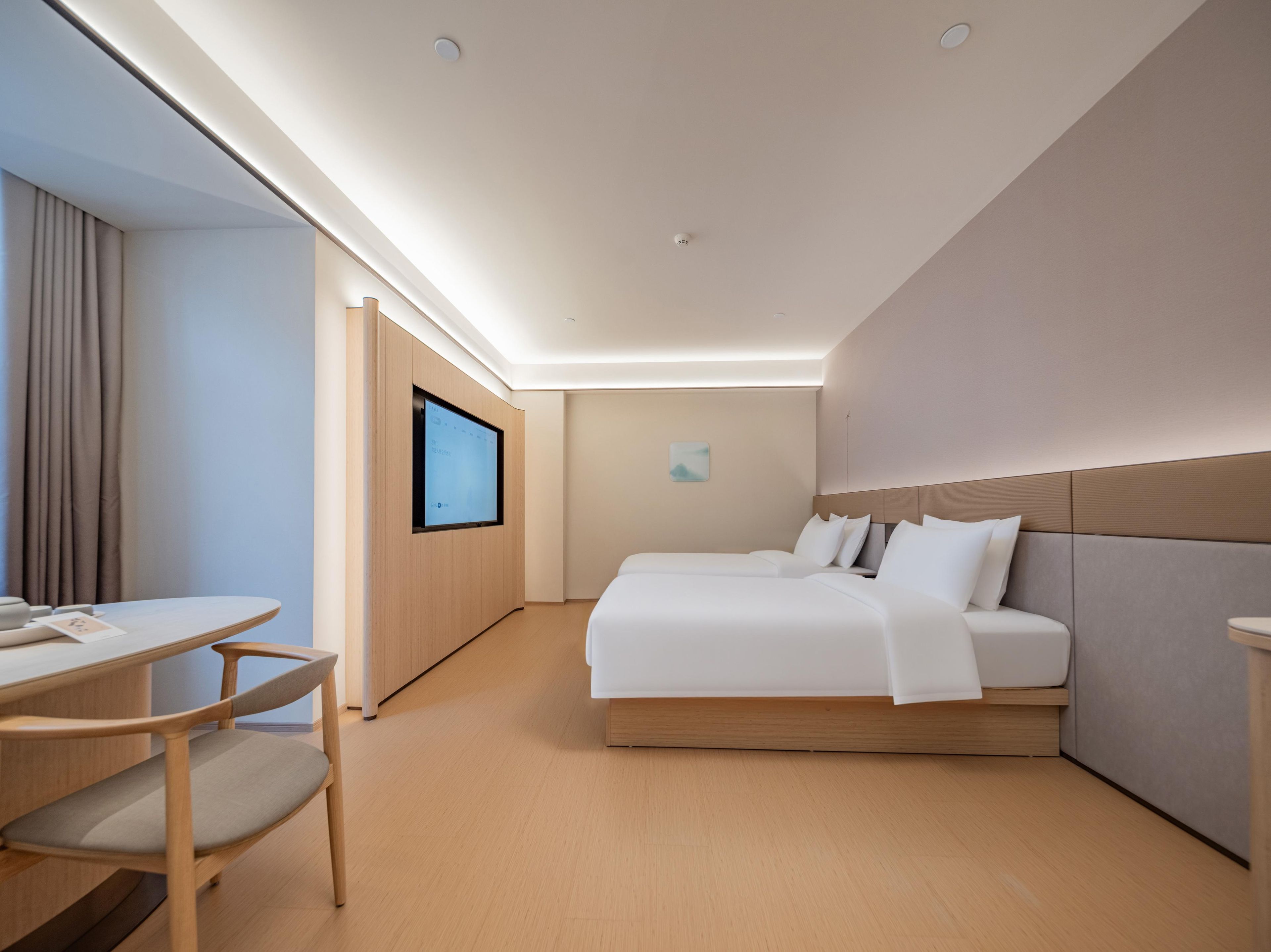 A hotel room with a bed, a desk, and a television.