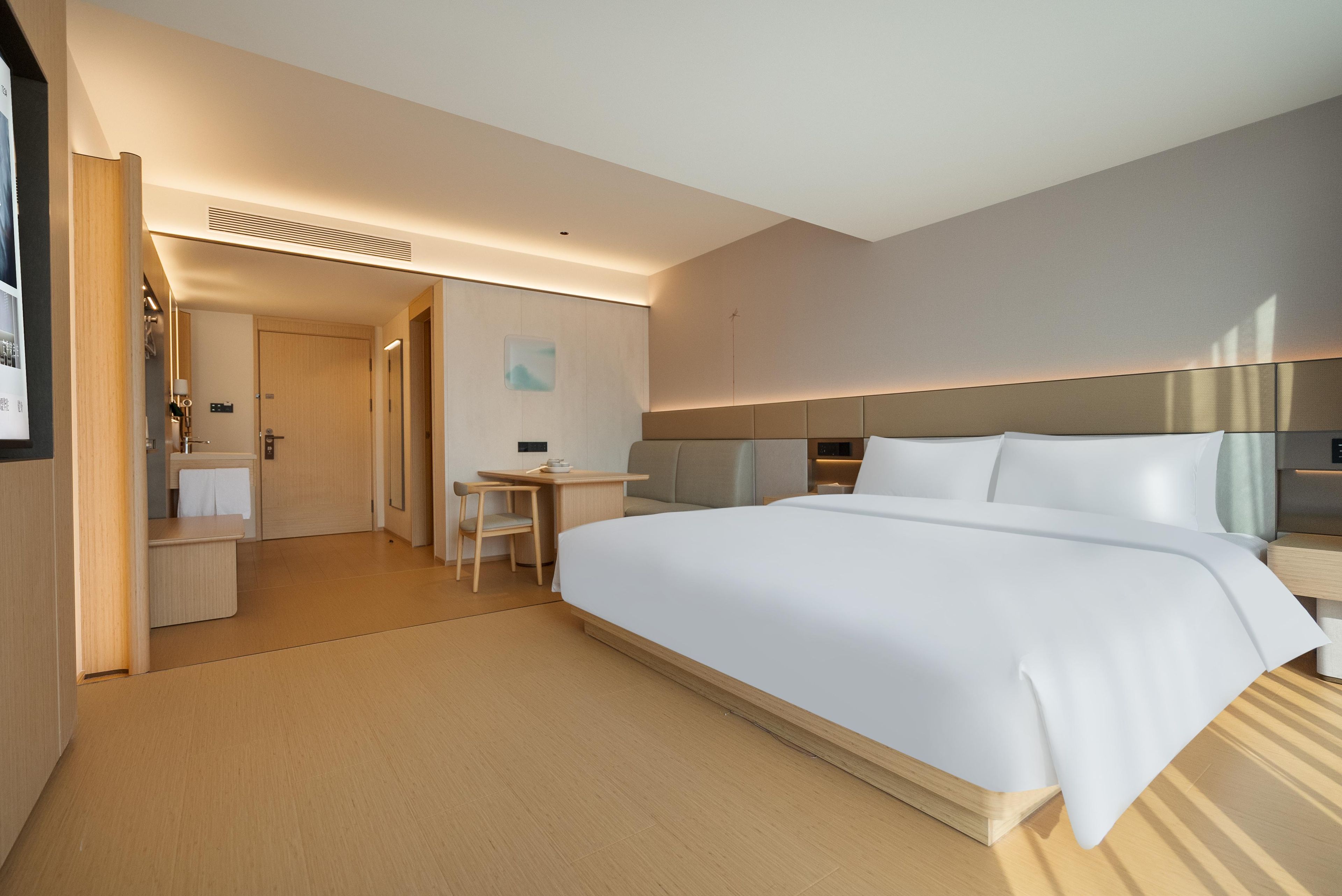 Een hotelkamer met een groot bed, een bureau en een stoel.