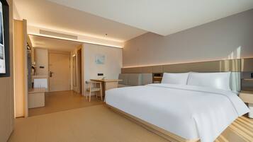 Een hotelkamer met een groot bed, een bureau en een stoel.