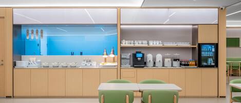 A modern kitchen area with a blue backsplash, stainless steel appliances, and a coffee machine.