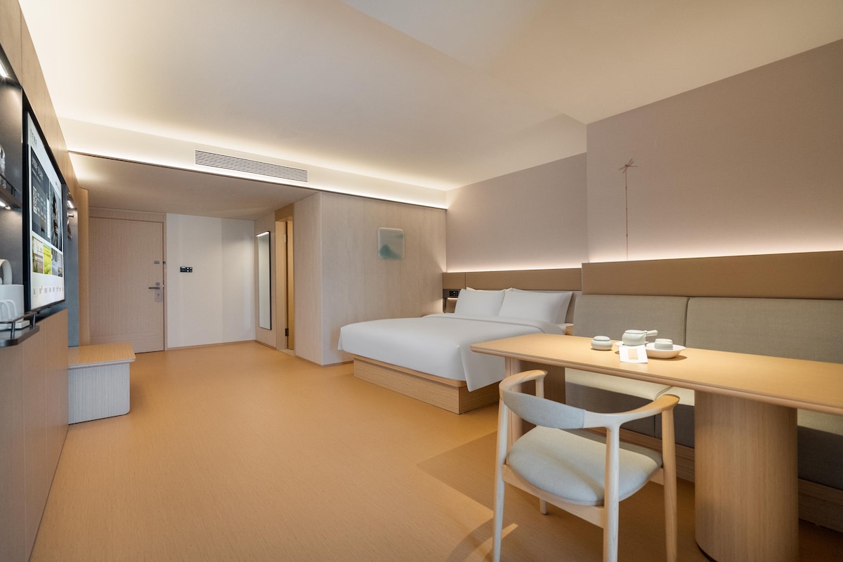 Una habitación de hotel moderna con una cama, un escritorio y una silla.