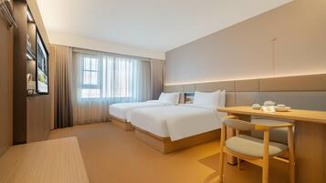A hotel room with a bed, a desk, and a chair.