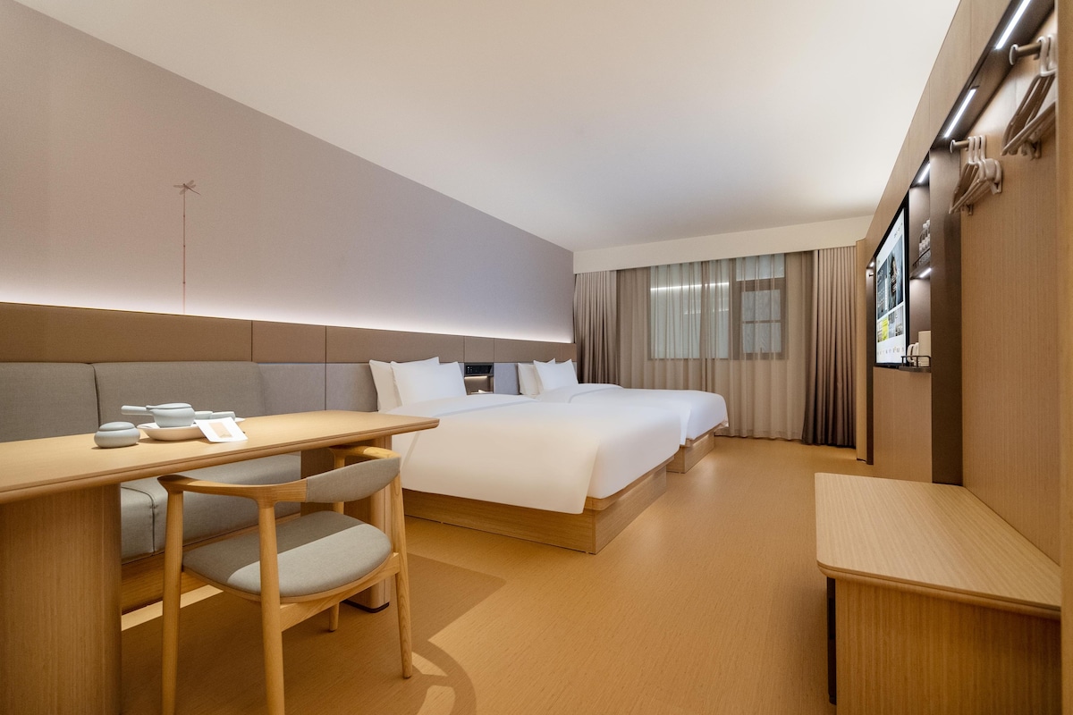 Habitación de hotel con una cama grande, un escritorio con una silla y una televisión.