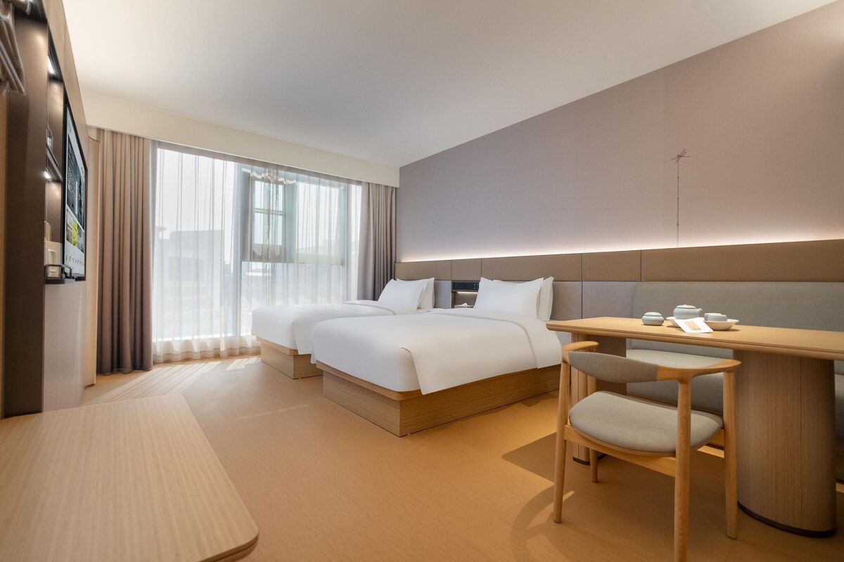 Una habitación de hotel moderna con una cama grande, un escritorio y una silla.