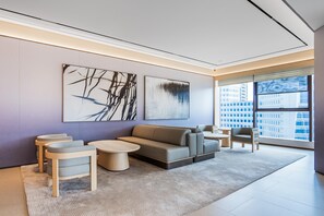 A modern living room with a sofa, two armchairs, a coffee table, and abstract wall art. - JI Hotel (xian Bell Tower Dachaishi Metro Stat (Xi'an)