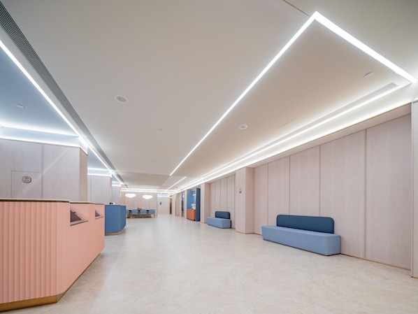 A modern hotel lobby with a long reception desk, seating areas, and a clean, minimalist design. - Hanting Hotel Xian Bell Tower Dachaishi Metro St (Xi'an)