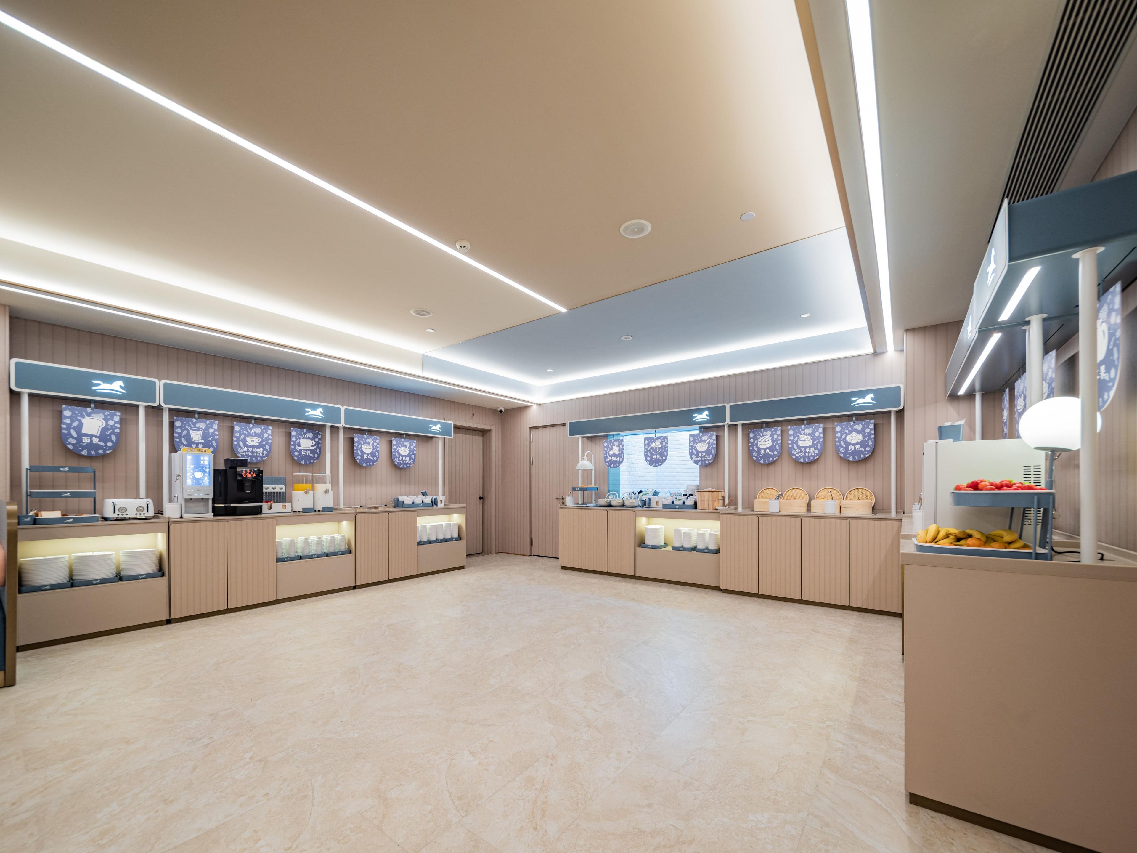 A clean, modern cafe interior with two service counters, a coffee machine, and a fruit display.