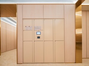 A wall with numbered lockers, a digital lock, and informational signs. - Hanting Hotel Xian Bell Tower Dachaishi Metro St (Xi'an)