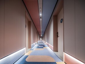 A hotel corridor with a checkered carpet, doors on both sides, and a ceiling with recessed lighting. - Hanting Hotel Xian Bell Tower Dachaishi Metro St (Xi'an)