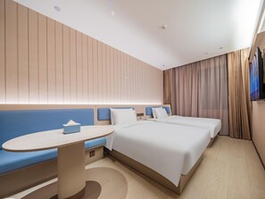 A modern hotel room with a large bed, a seating area with a table, and a television mounted on the wall. - Hanting Hotel Xian Bell Tower Dachaishi Metro St (Xi'an)