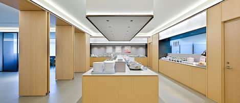 A modern kitchen with a central island, wooden cabinets, and a variety of kitchenware.