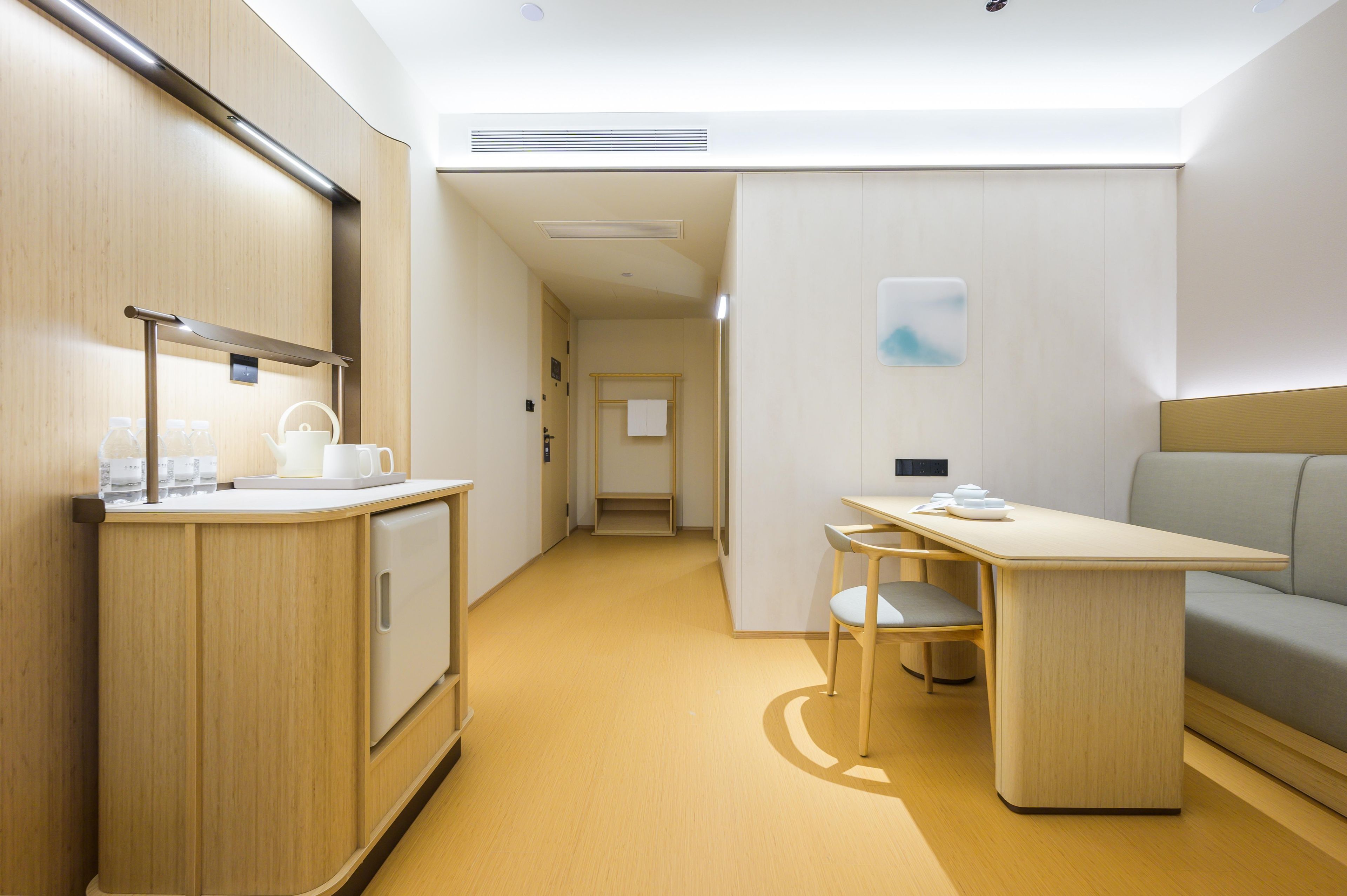 Una habitación de hotel moderna con kitchenette, comedor y zona de estar.