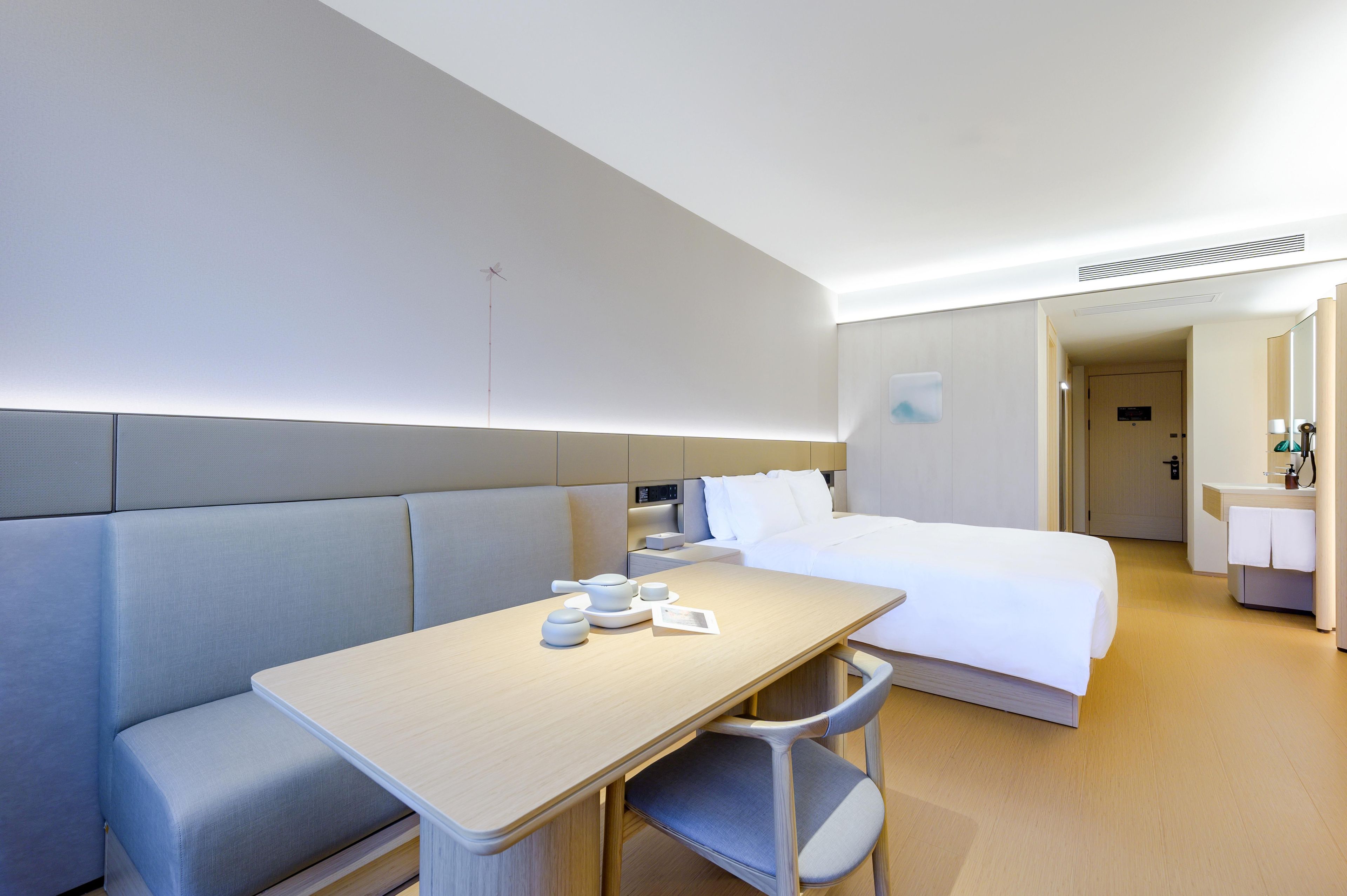 Una habitación de hotel con cama, zona de estar con mesa y baño.