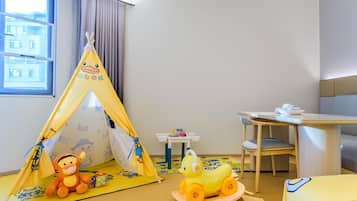 A child's play area with a yellow tent, a plush toy, and a toy vehicle.