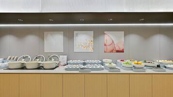 A buffet setup with various food items and bowls.