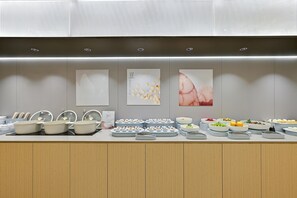 Montaje de bufé con diferentes alimentos y recipientes.