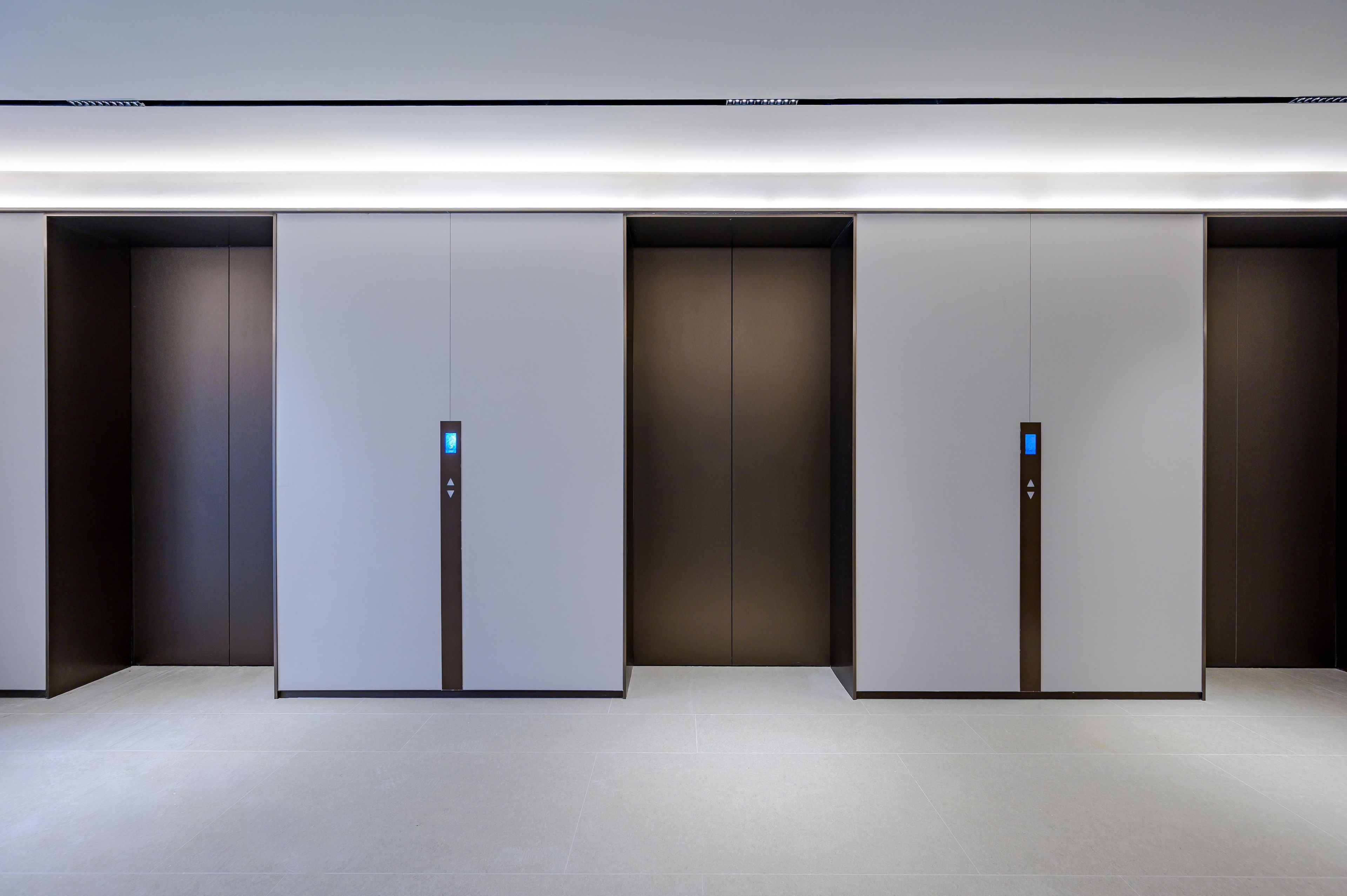 A modern elevator with a minimalist design, featuring a digital display and a simple control panel.