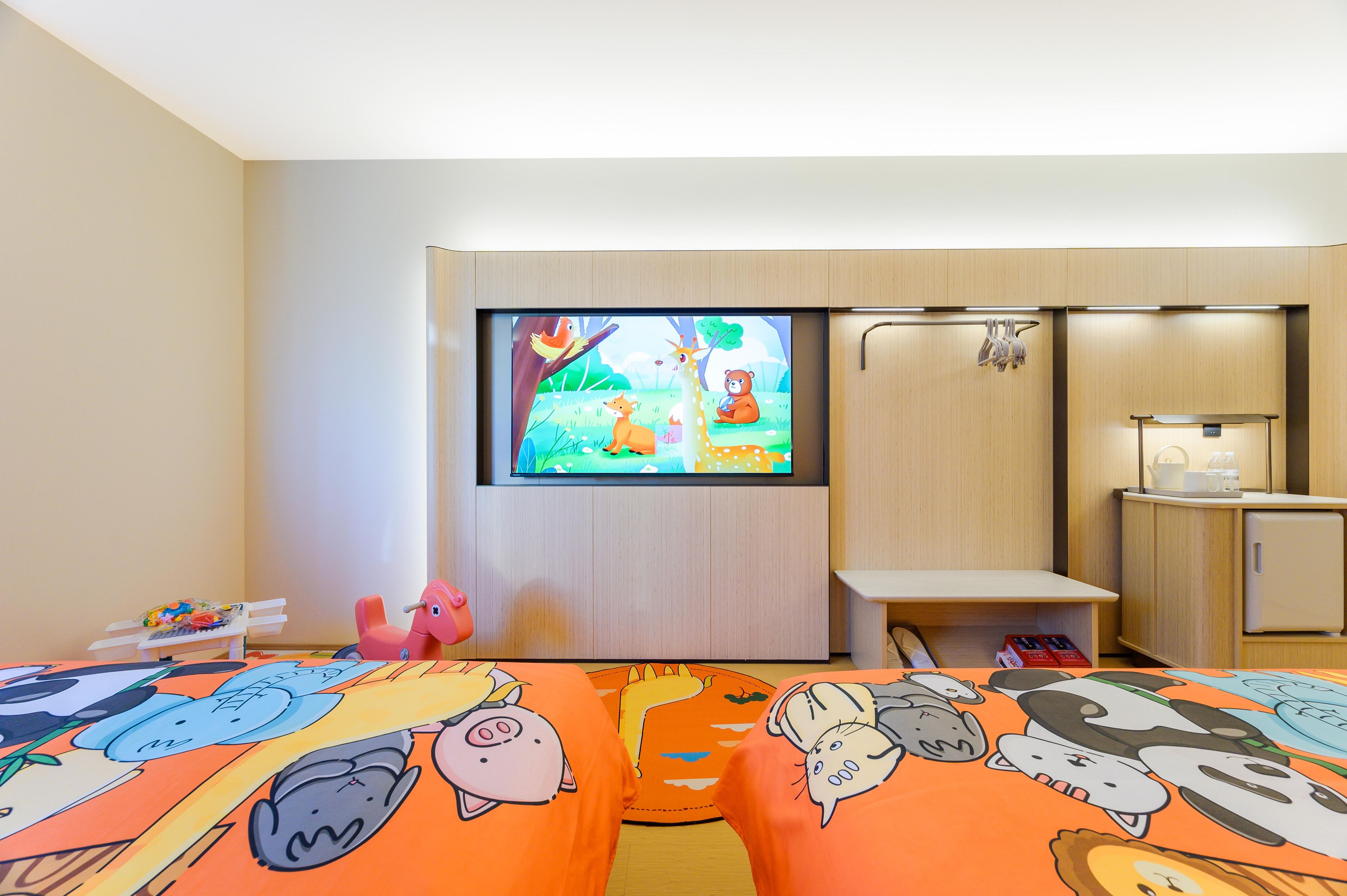 A hotel room with two beds, a television, a desk, and a wardrobe.