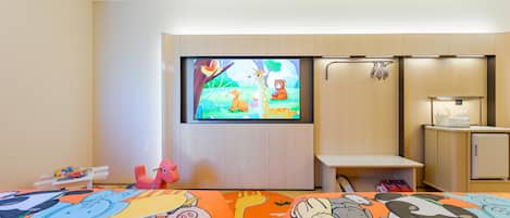 Habitación de hotel con dos camas, televisor, escritorio y armario.