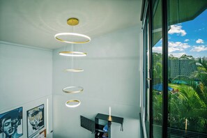 A modern interior with a large window, a unique ceiling light fixture, and artwork on the walls.