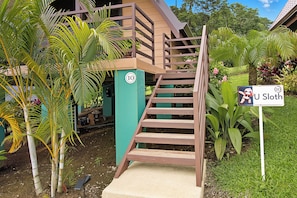 A wooden staircase leading to a building with a green pillar marked with the number 10. - Junglo Resort And Spa (Peñas Blancas)