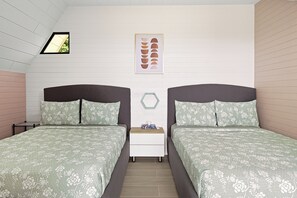 A bedroom with two beds, a nightstand, a framed picture, and a window. - Junglo Resort And Spa (Peñas Blancas)