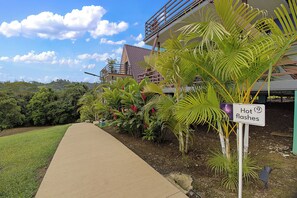 A pathway leading to a building with a sign indicating 'Hot flashes'. - Junglo Resort And Spa (Peñas Blancas)