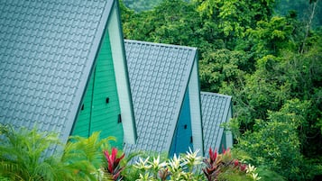Une rangée de bâtiments aux toits végétalisés, entourés d’une végétation luxuriante.