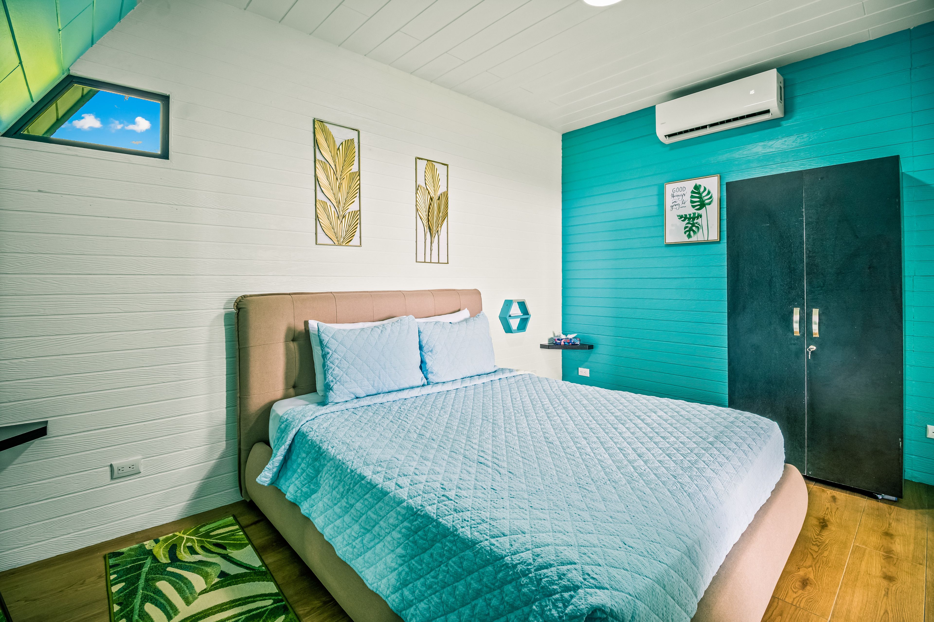 Une chambre à coucher comprenant un lit, une armoire et un climatiseur fixé au mur.