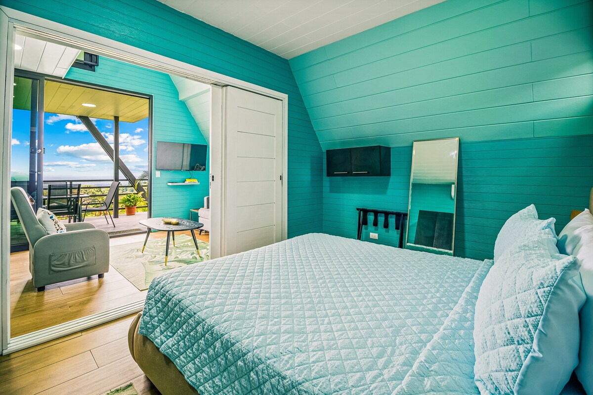 Un dormitorio con cama, una silla, una mesa y un balcón con vistas.