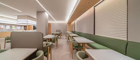 A modern dining area with booths and tables, featuring a neutral color palette and contemporary design.