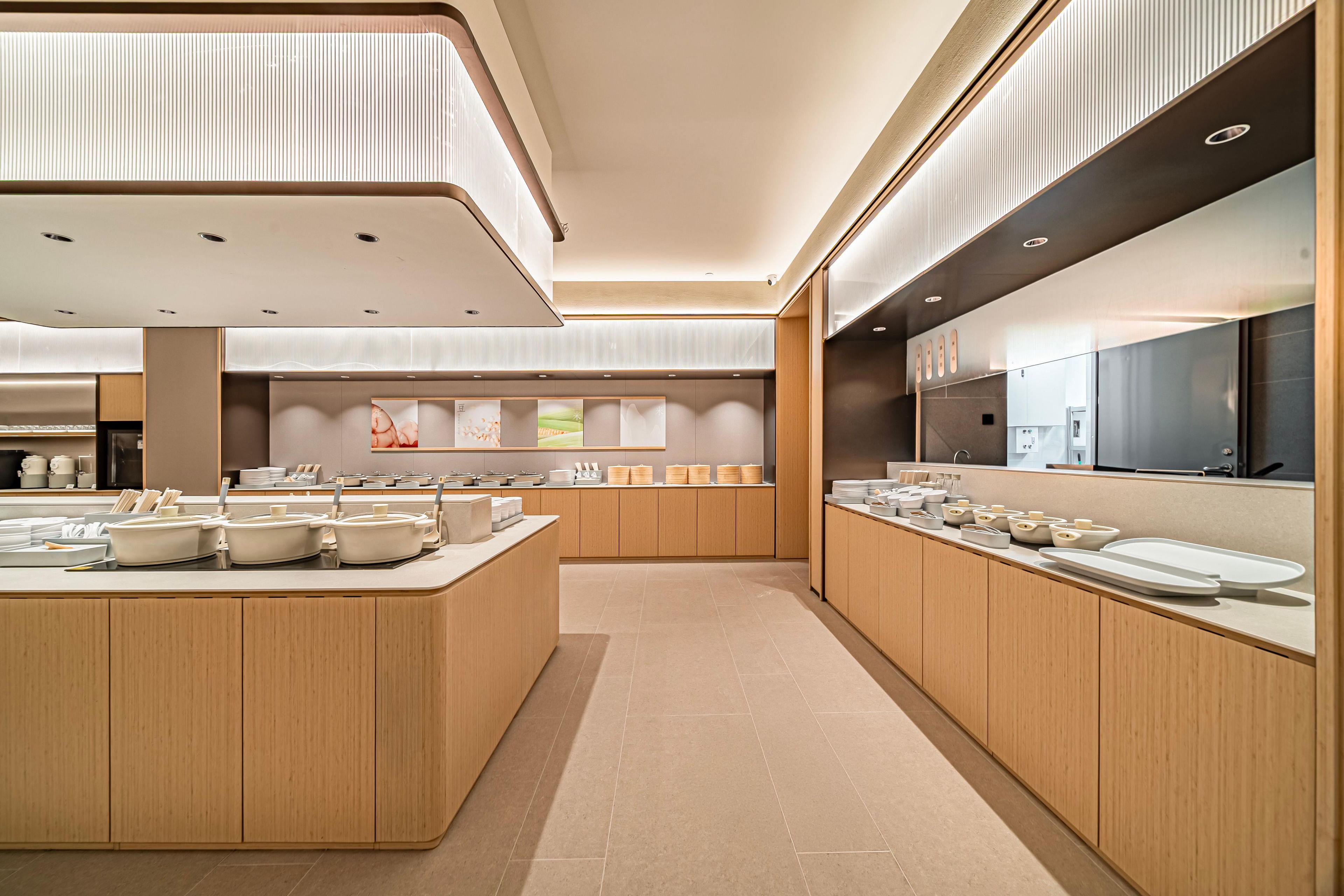 Una cocina moderna con una isla central, armarios de madera y un refrigerador grande.