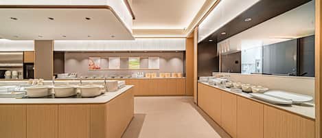 A modern kitchen with a central island, wooden cabinets, and a large refrigerator.