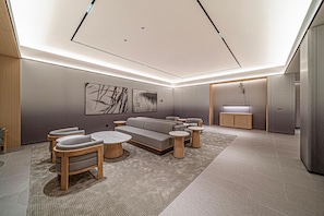 A modern interior with a sofa set, round tables, and a minimalist design. - JI Xian Bell Tower Yongning Gate Metro Stat (Xi'an)
