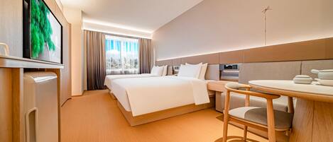 A hotel room with a bed, a desk, and a television.