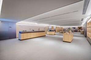 A modern hotel lobby with a reception desk, seating area, and a hallway leading to other rooms. - JI Hotel (Xi'an)